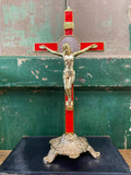 Gold and red decorative crucifix on a stand