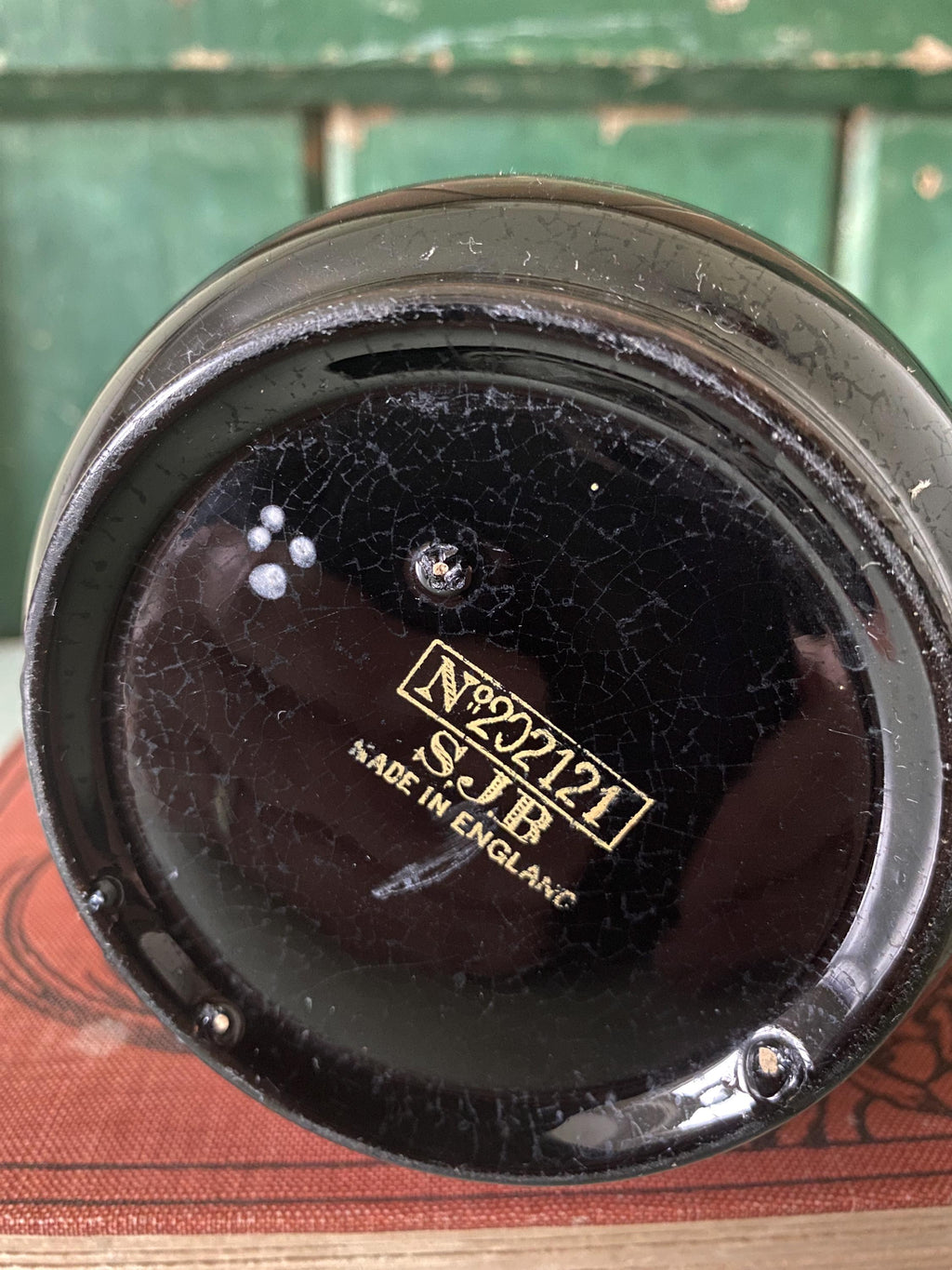 Close-up of the base of a black ceramic jug with 'SJB' branding