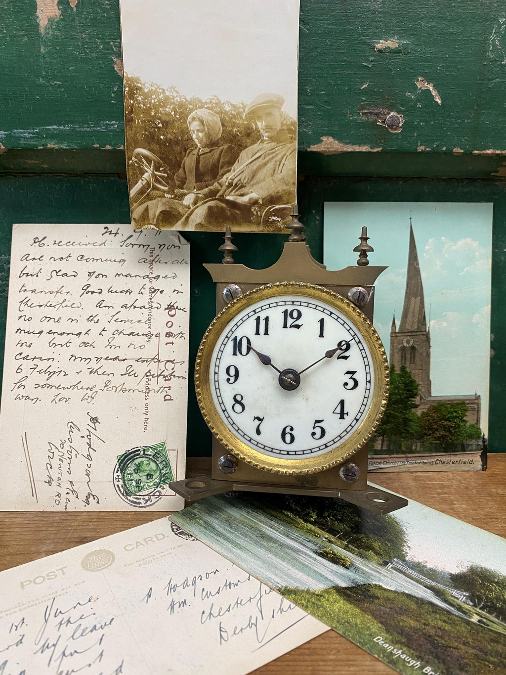 Vintage clock with old photographs and letters on a wooden surface