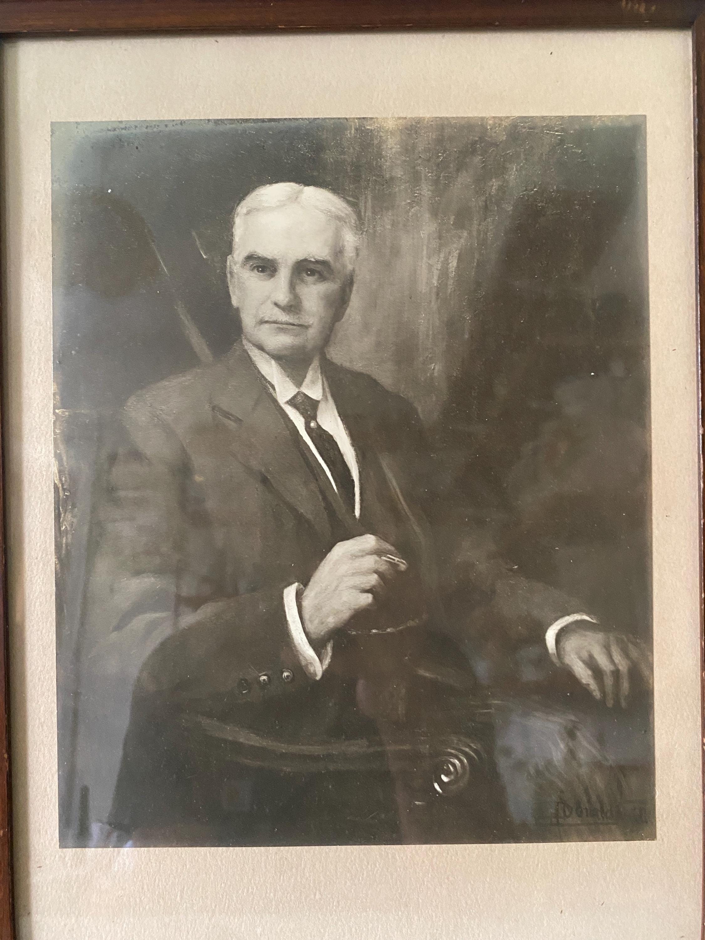 Vintage black and white portrait of a man in formal attire with a blurred background