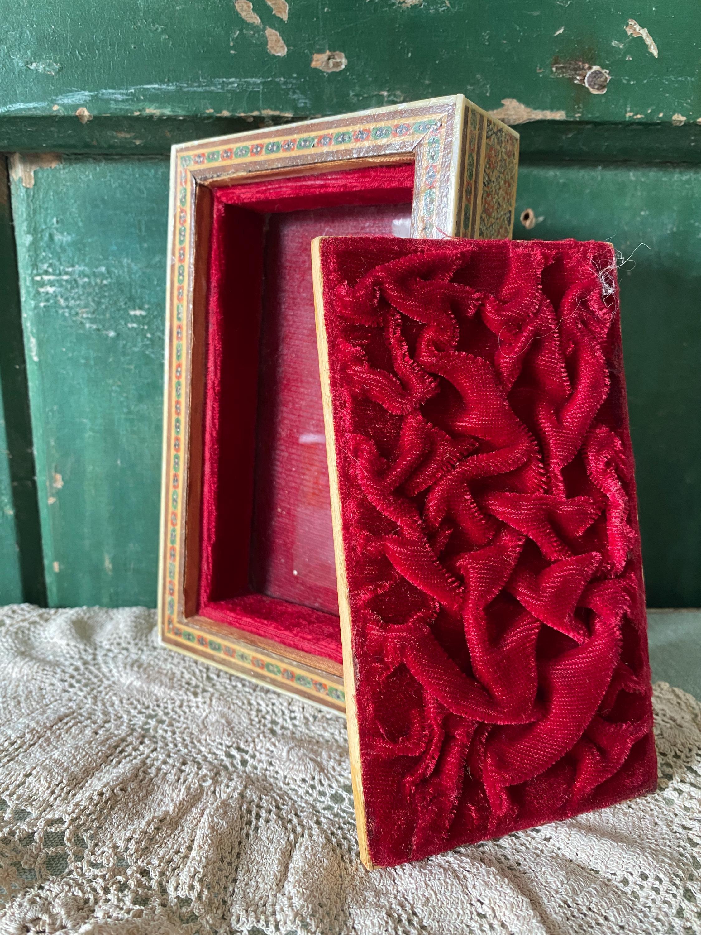 Red velvet interior of a box with intricate design