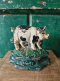 Decorative black and white hand painted pig figurine standing on green base