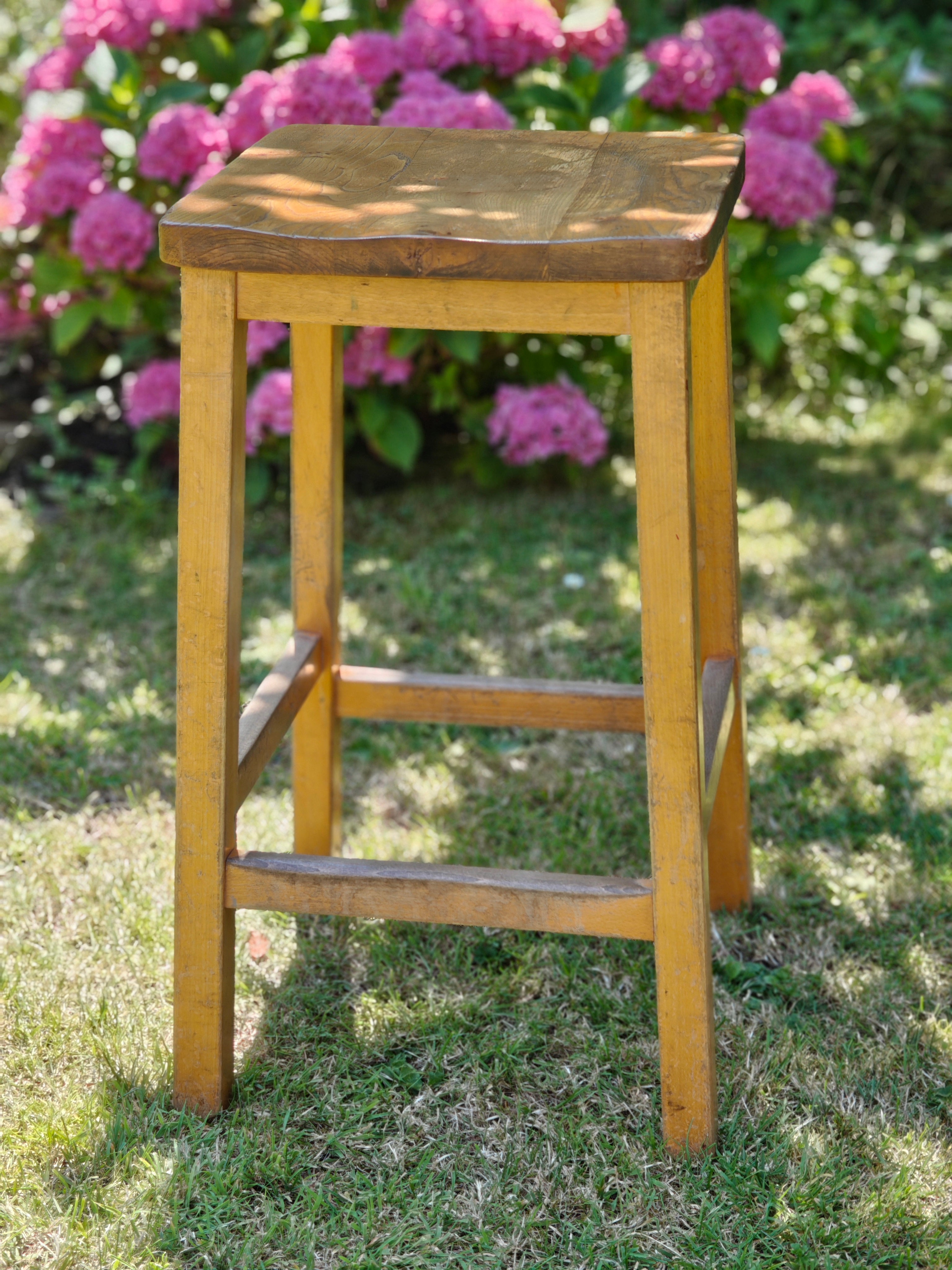 A vintage wooden lab stool
