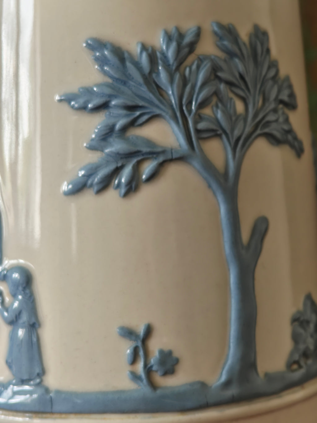 Decorative ceramic piece with a tree and figure in blue