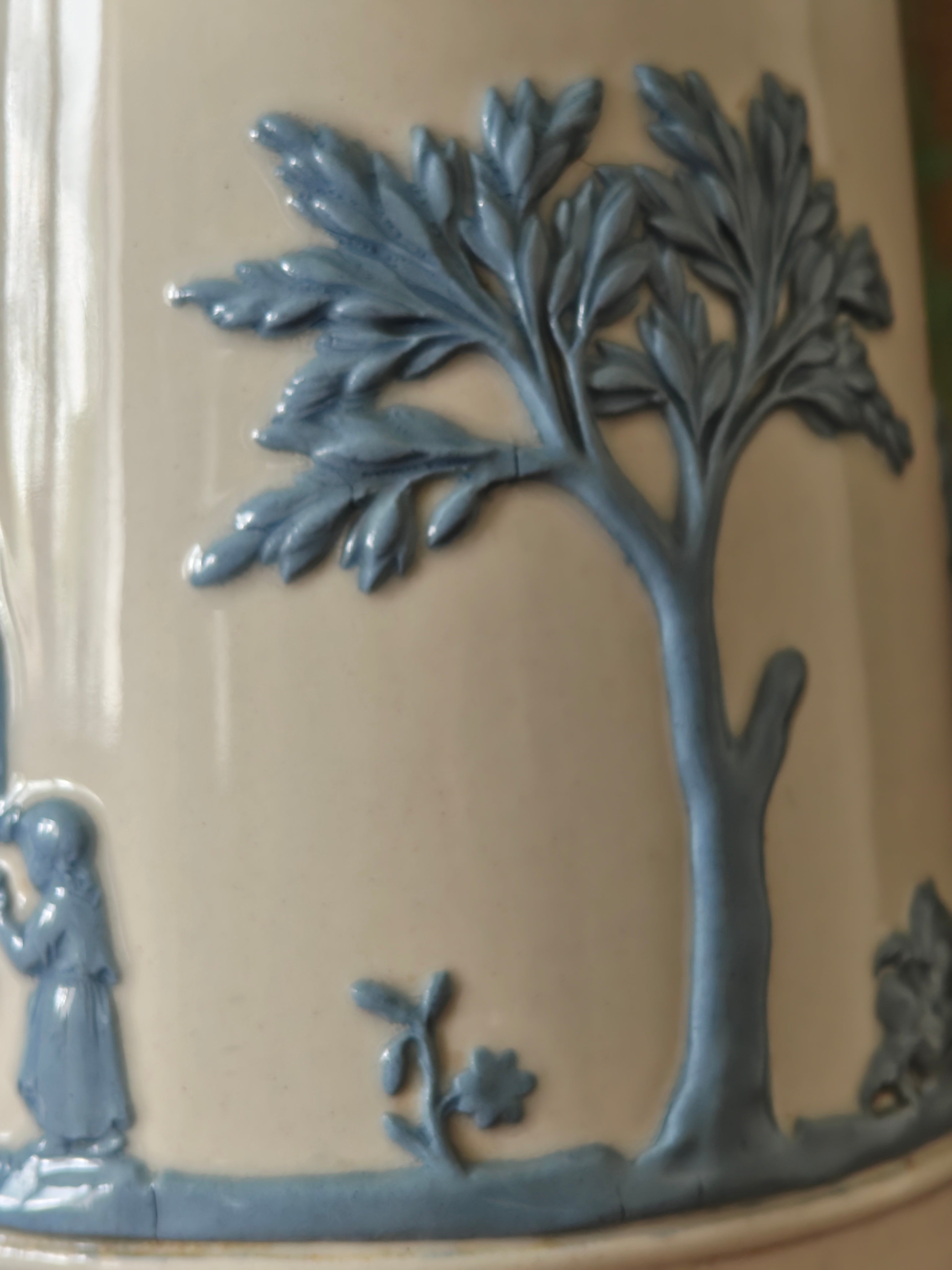 Decorative ceramic piece with a tree and figure in blue